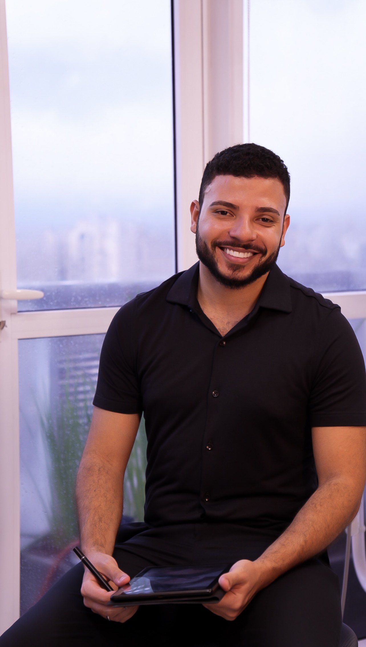 Dr. Mateus Bonutty na sala de atendimento, com a luz natural da Avenida Paulista ao fundo